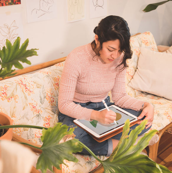 young female portrait of an artist, drqwing on ipad, in home setting