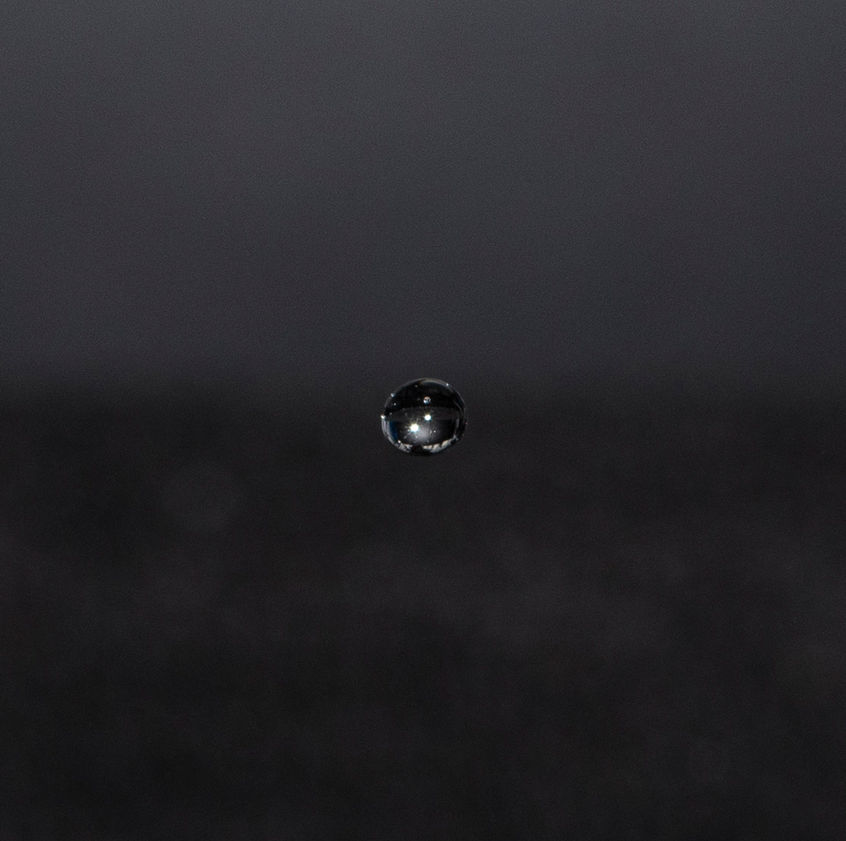 Still life photography. Single water droplet again dark background