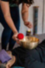 A student resting deeply under a blanket while experiencing the vibrations of a sound bath