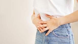 胃のあたりをおさえる女性