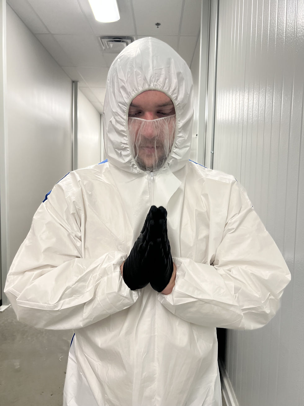 Luc Carlin (LMC) — Wearing a white protective suit and black gloves.