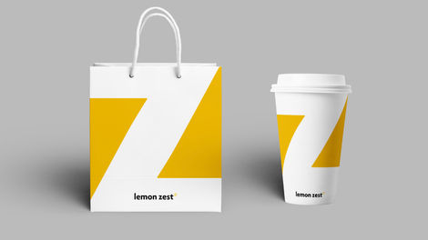 lemon zest branding shown on a paper bag and coffee cup packaging