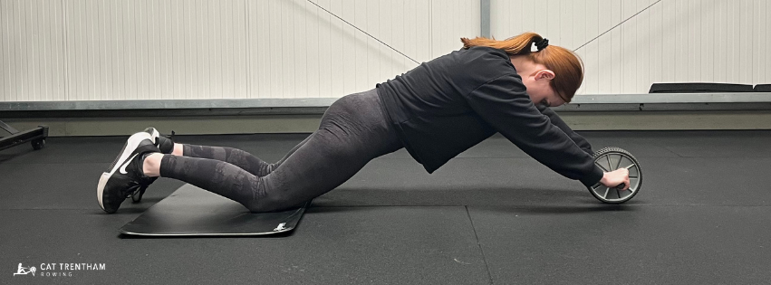 Athlete demonstrating an ab rollout while maintaining a strong braced position