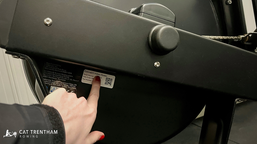 Serial number sticker on the back of a Concept2 rowing machine flywheel housing, with the location indicated.
