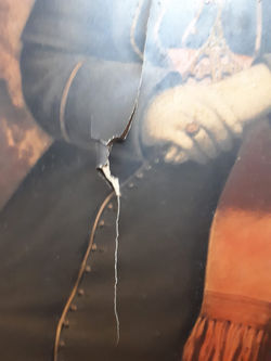 Retrato em suporte de papel com danos estruturais severos