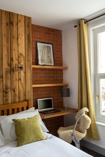 Wood cladding and brick feature in bedroom