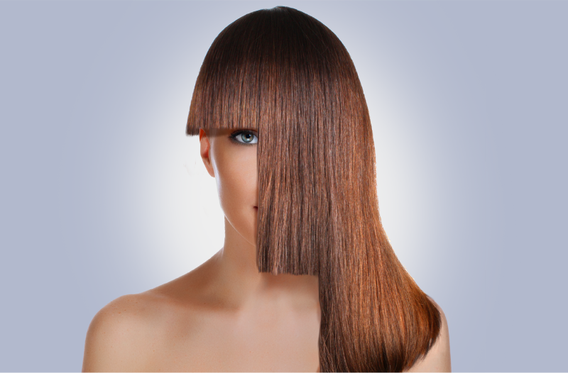 Portrait of a young woman with short, middle and long hair cut in front of her face.