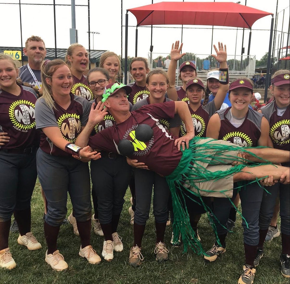 Coach Gill is being held by members of the Wabash Mission Softball team. His oldest daughter Rachel Gill is located in the center of the front row.