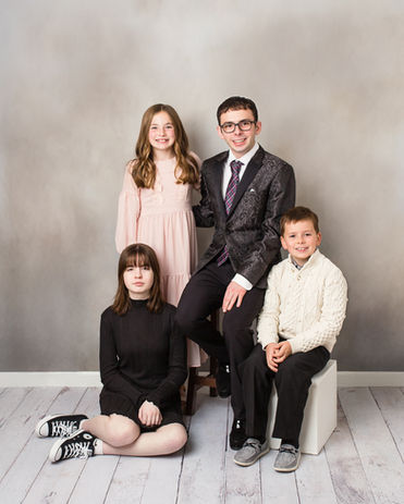 Four siblings in a posing together in a studio photography session