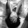 a woman holds her hands over her face_ed
