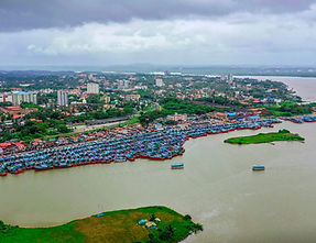 Mangaluru coastline with sandy beach, coconut palms, and St. Aloysius Chapel hill in the backdrop.