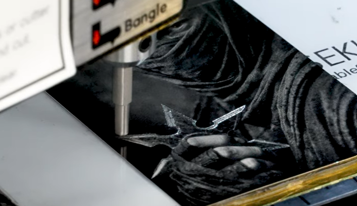 "Laser photo engraving and CNC machining in progress on the Janus hybrid engraving machine, creating a custom jewelry pendant."