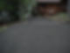 Gravel cottage driveway installation with integrated trench drain system for proper water drainage and erosion control