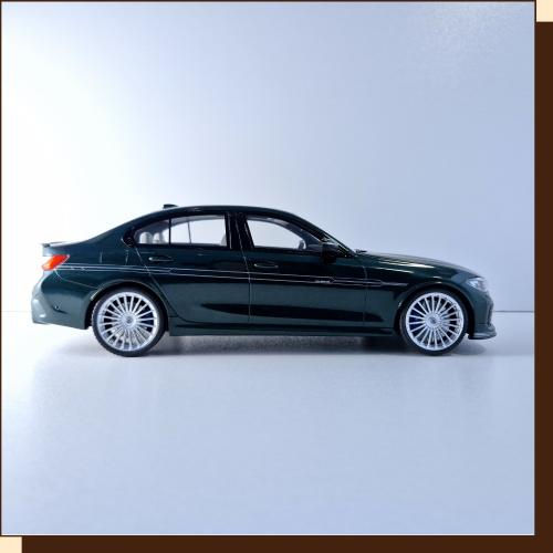 Thumbnail: Zijaanzicht donkergroene BMW sedan met zilveren velgen op een witte achtergrond.