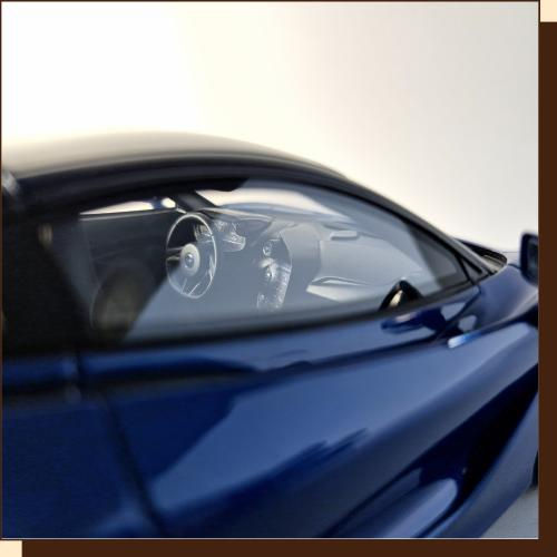 Thumbnail: Blauwe sportwagen detailfoto met interieur en stuur, glimmende lak, raam, helder zicht.