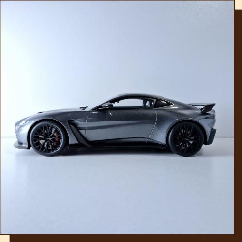 Thumbnail: Zilveren Aston Martin sportwagen geparkeerd op witte ondergrond. Strakke lijnen.