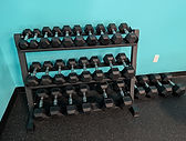 Picture of set of dumbbells on a dumbbell rack inside of Wicked Fitness