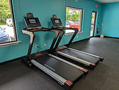 Picture of 2 treadmills by front windows of Wicked Fitness