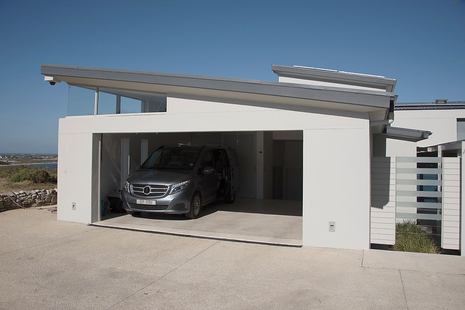 Car parked in garage with concrete driveway.