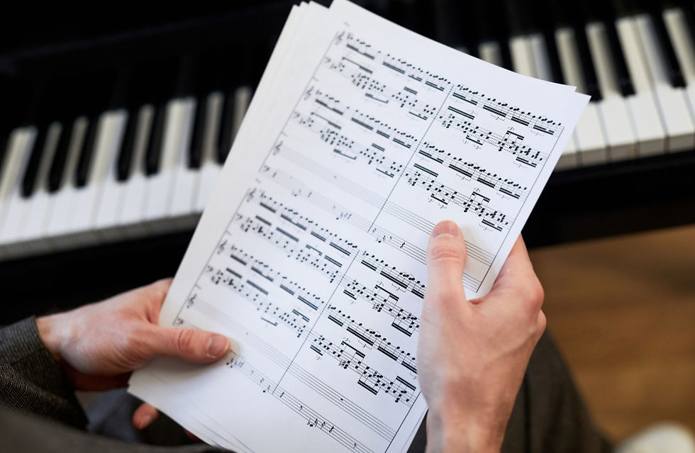 Hand holding a music sheet