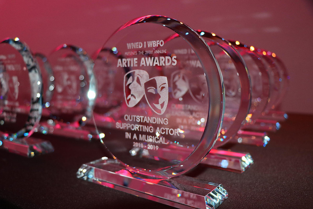 glass award trophies lined up on a table