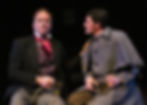 two men in Victorian clothes have mugs of beer