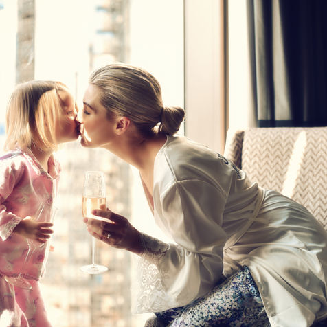 Woman in a robe kissing a child in pajamas