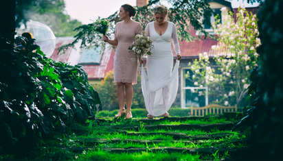 Bride and bridesmaid walking down garden stairs