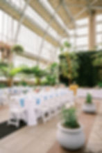Reception table setting with bright pastel floral centerpieces, light blue napkins, and floating candles in glass cylinders, setup by the Blue Diamond Events Luxury Wedding Planning + Coordination Team at a Korean - Mexican Multicultural Wedding at The Jewel Box at Forest Park in downtown St. Louis, MO.