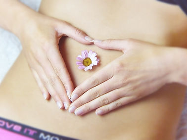 Woman with hands over uterus in a triangle shape