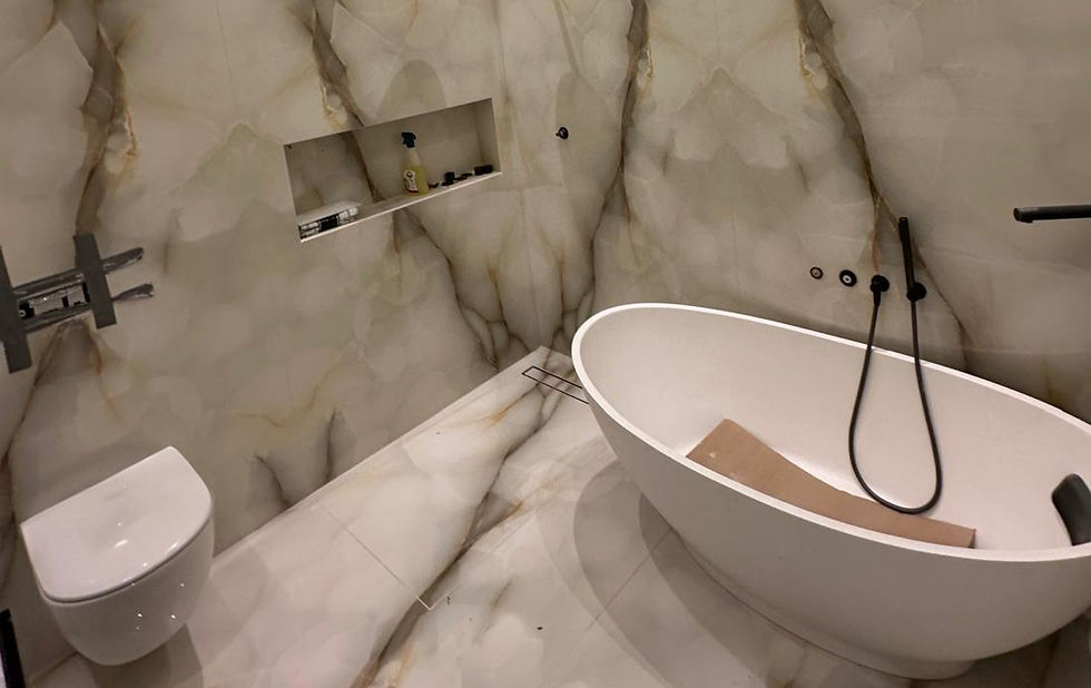 Marble-effect bathroom with a freestanding bath and shower in the THRC Construction portfolio
