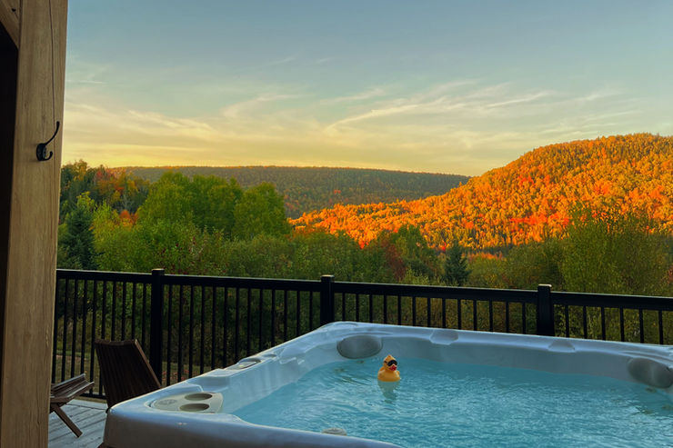 Hot tub with stunning views overlooking sunlit autumn hills at sunset. Stoke Resorts, Sussex, NB