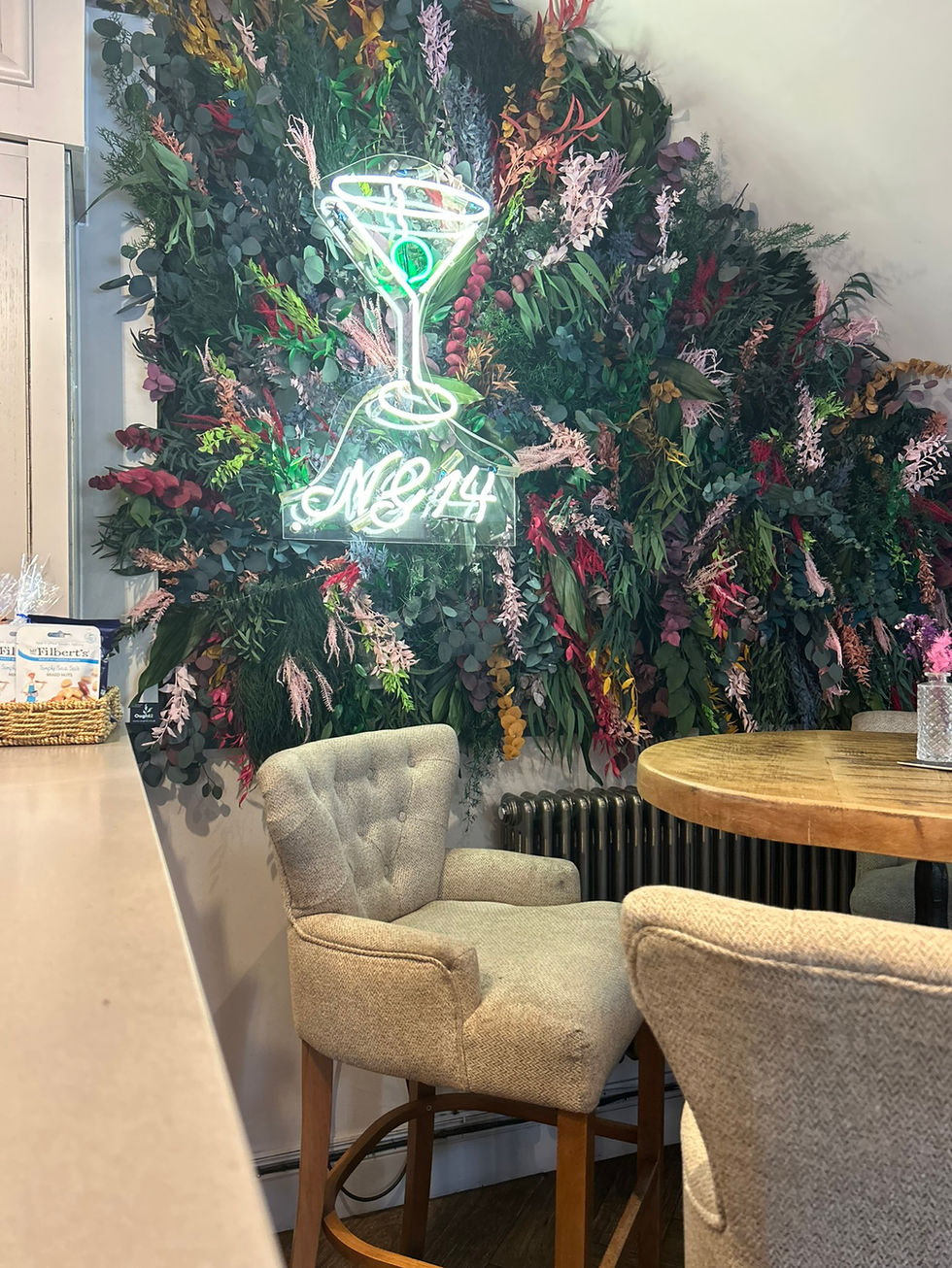 Neon sign on a plant wall.
