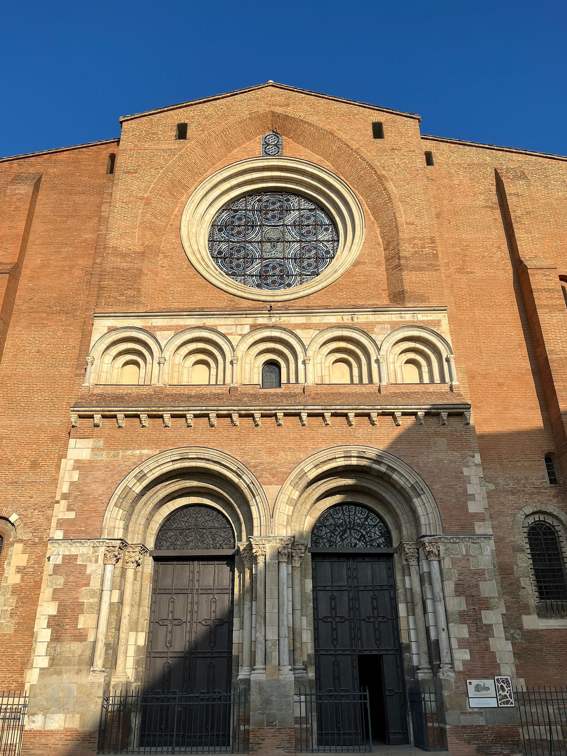 Schöne alte Türen und Verwendung von weissen stein und Ziegeln an der kürzlich renovierten Eingans der Basilika Saint-serrnin in Toulouse.