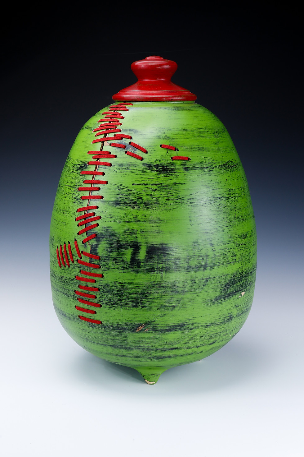 Thumbnail: Green and Black maple hollow vessel with red stitching.