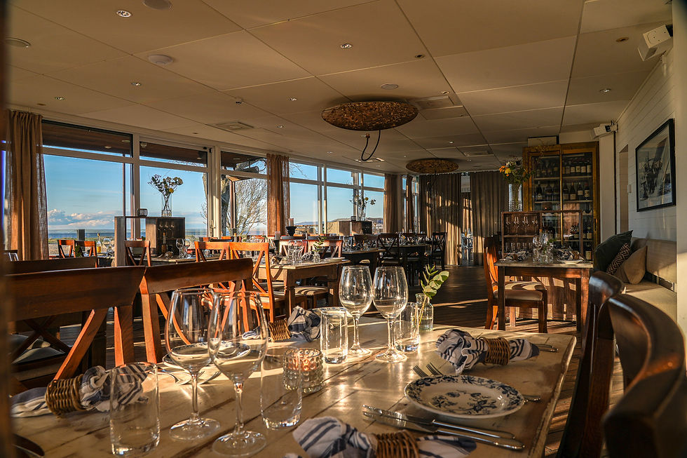 En kvällsbild som visar Papas Restaurang med sin uteservering vid hamnen i Båstad.