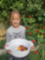 smiling student in garden harvesting flowers