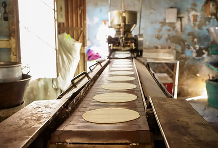 Corn tortillas are coming out in series from the machine