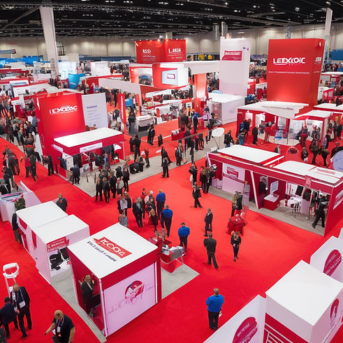 large lexograpghic trade show with booths and label printing presses and people all around