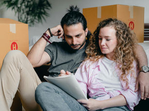 Couple of expats writing in notebook while packing before their move abroad