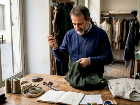 Italian tailor hand-stitching in sunlit studio