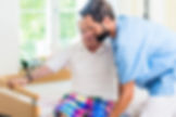 male caregiver transferring male senior from wheelchair