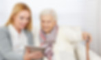 senior and caregiver looking at notebook
