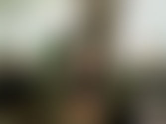 Caregiver assisting elderly women with tea in a cozy nursing home setting.