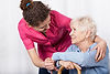 female senior sitting on chair female caregiver comforting senior