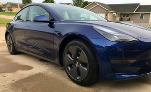 Side view of shiny detailed blue Tesla