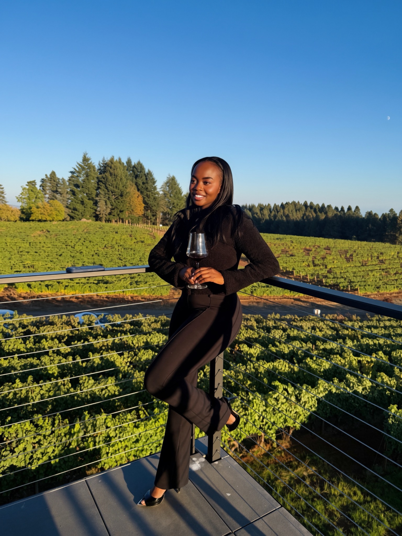 Hadassah holding a glass of wine on a vineyard terrace