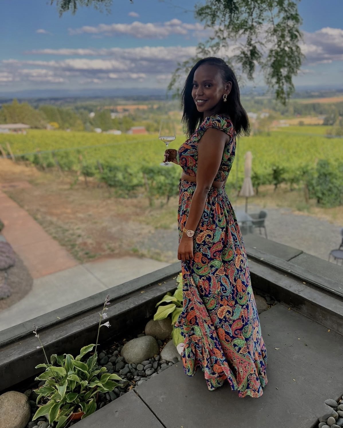 Grace enjoying wine overlooking a vineyard