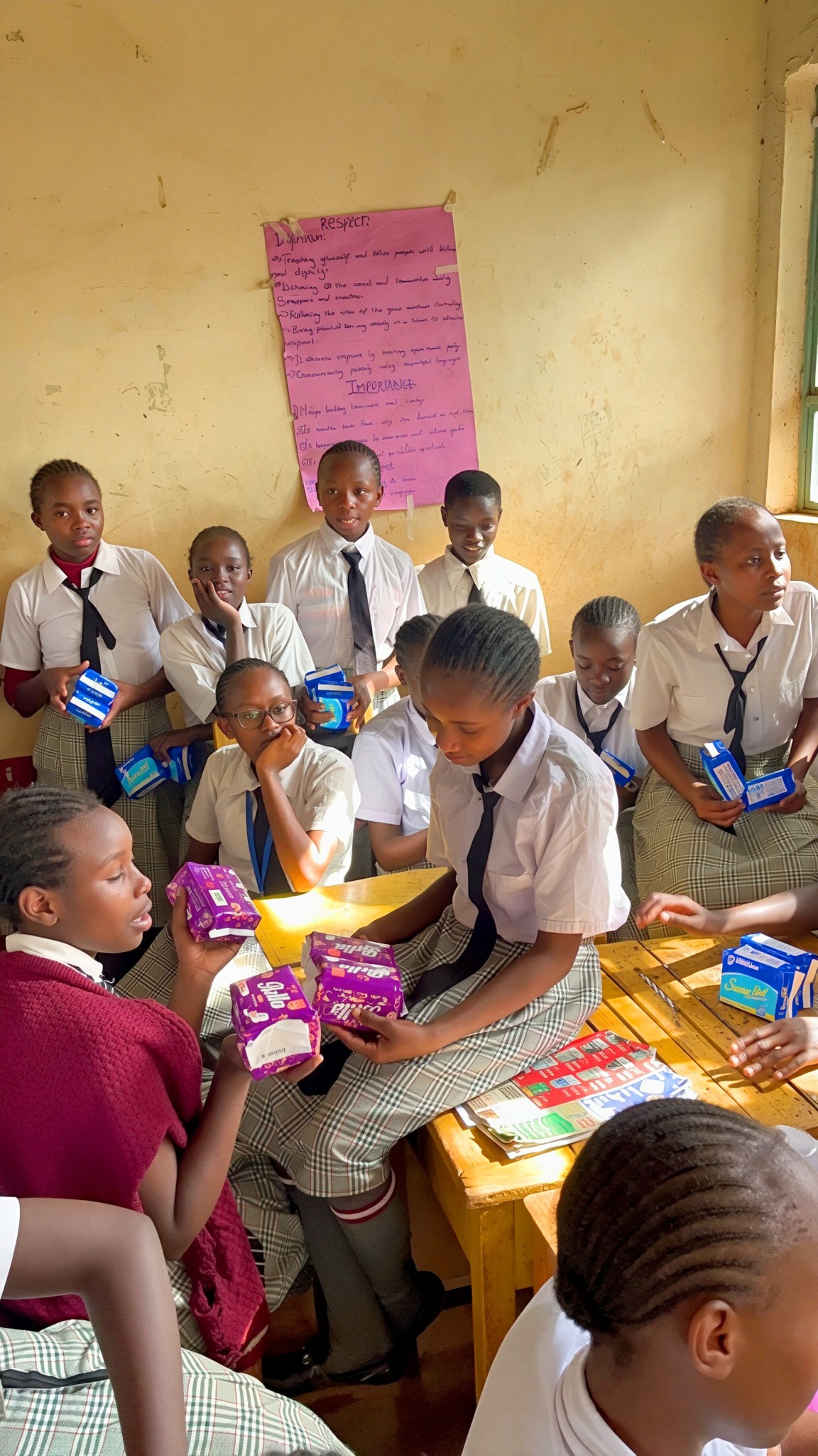 Sanitary pads being shared with students around a classroom table