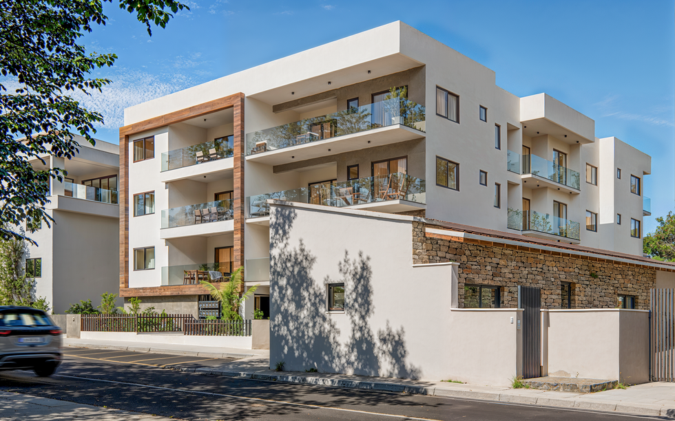 3D exterior rendering of a modern residential apartment building, showcasing balconies, wood cladding and soft natural lighting.